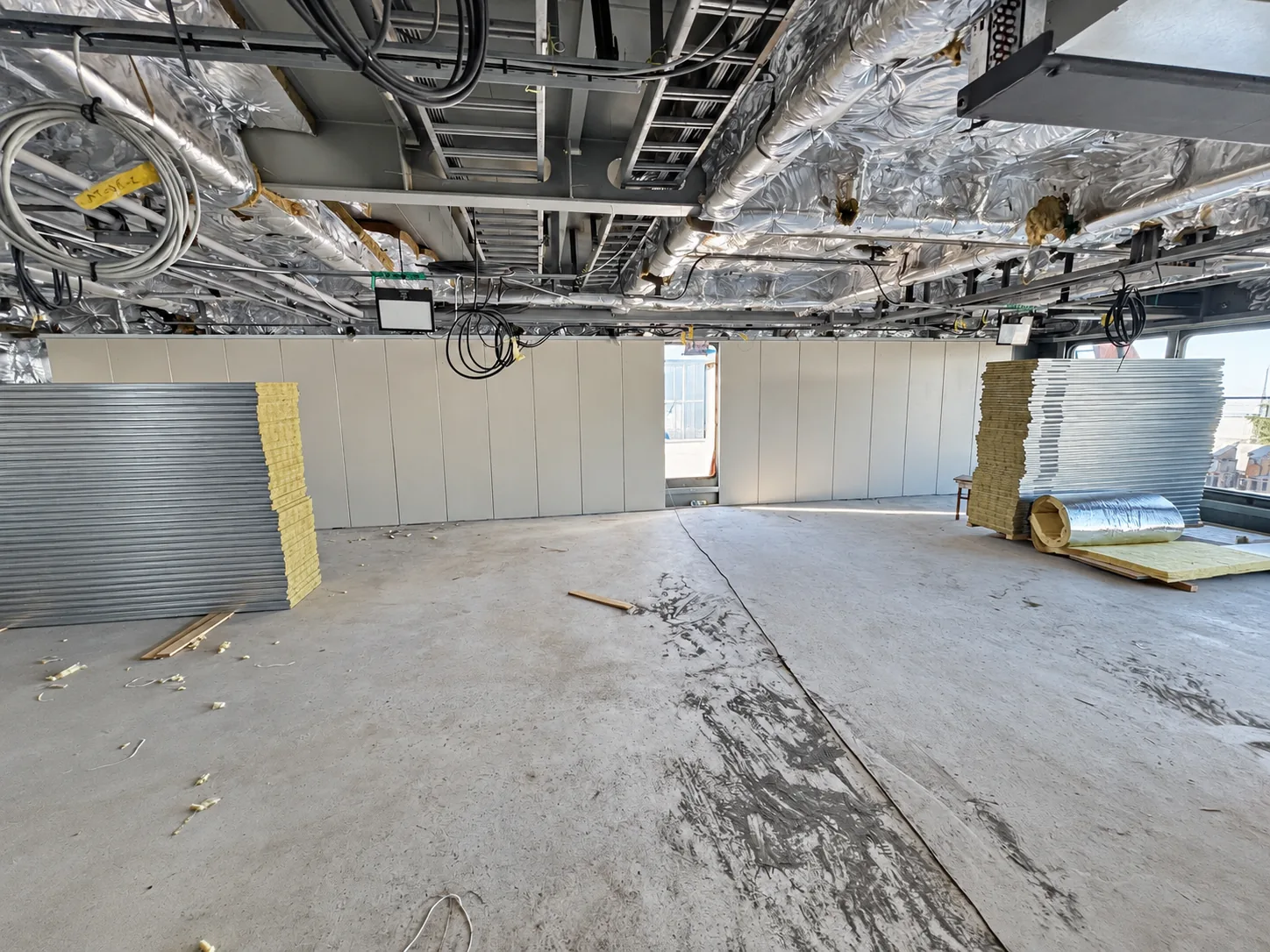 Marine interior installation progress with wall panels and overhead service interfaces